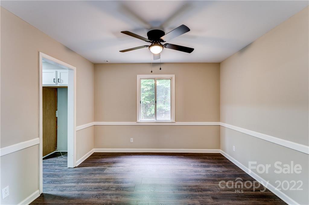 3088 Point Clear Drive Tega Cay, SC 29708 - Photo 7 of 32 an empty room with wooden floor chandelier fan and windows