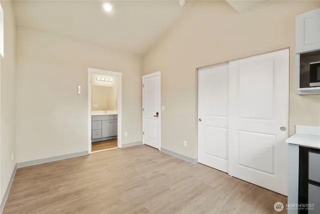 a view of a livingroom with wooden floor and a kitchen space