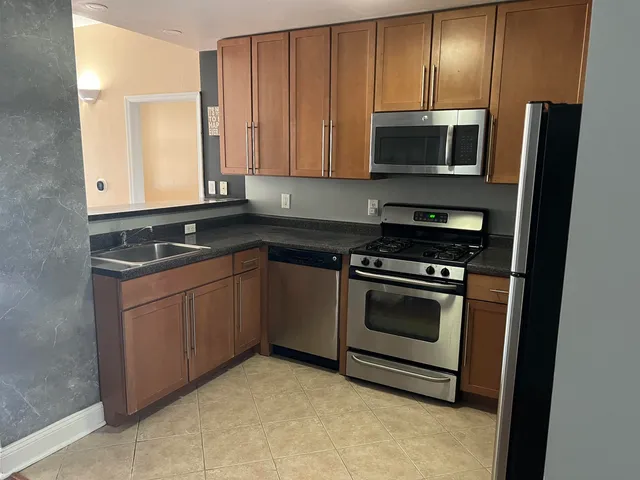a kitchen with granite countertop a stove and a microwave