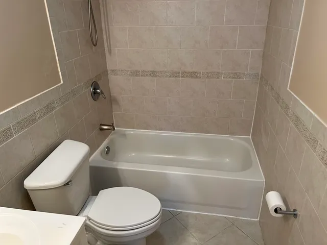 a white toilet and tub sitting next to a bathroom sink