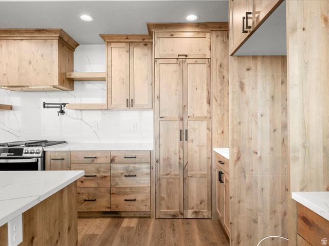 1159 North Broad Hollow Road Garden City, UT 84028 - Photo 29 of 55 Kitchen featuring natural wood cabinetry, white countertops, a contrasting white and gray veined backsplash, and recessed lighting