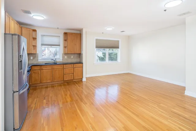 a view of a kitchen with wooden floor and a refrigerator