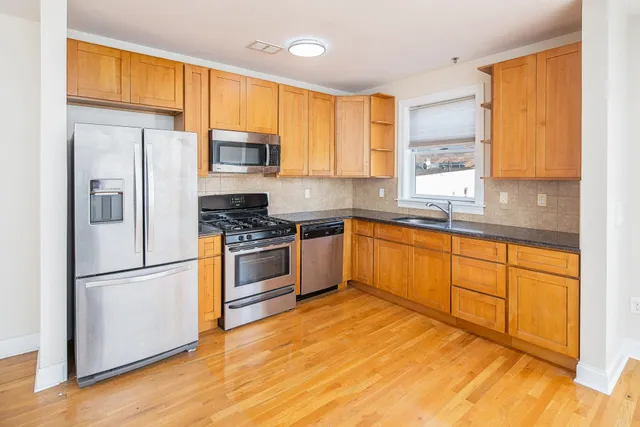 a kitchen with stainless steel appliances granite countertop a refrigerator sink and cabinets