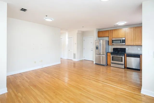 a view of a kitchen with wooden floor and electronic appliances