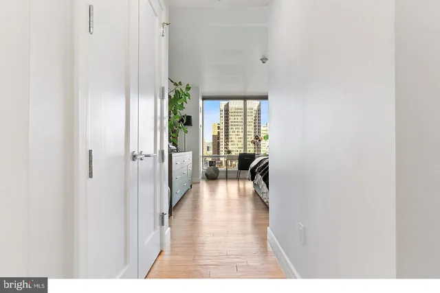 a view of a hallway with wooden floor fireplace and living room