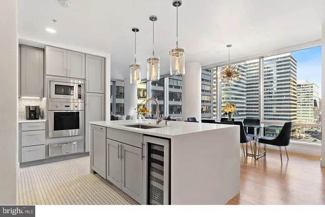 a kitchen with kitchen island granite countertop a stove a sink a oven a dining table and chairs