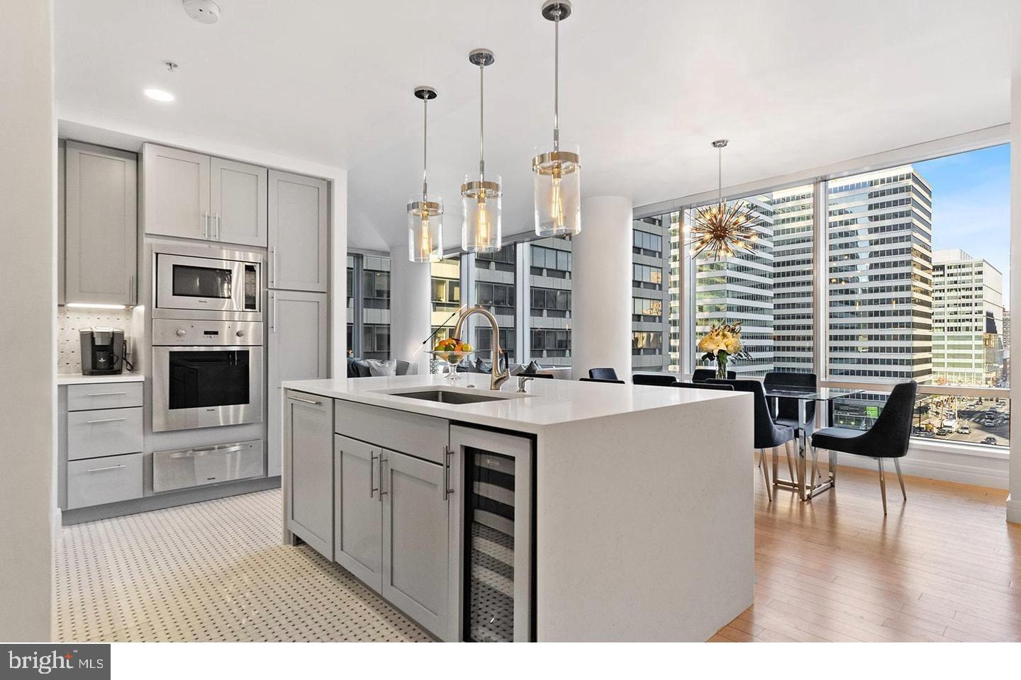 1414 South Penn Square, Unit 7F Philadelphia, PA 19102 - Photo 3 of 30 a kitchen with kitchen island granite countertop a stove a sink a oven a dining table and chairs