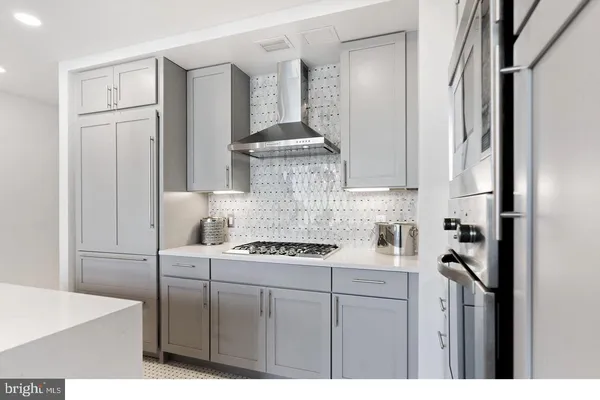 a kitchen with stainless steel appliances granite countertop a stove a refrigerator and a cabinets