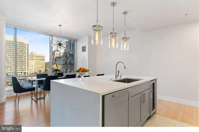 a view of kitchen island a sink wooden floor and living room view
