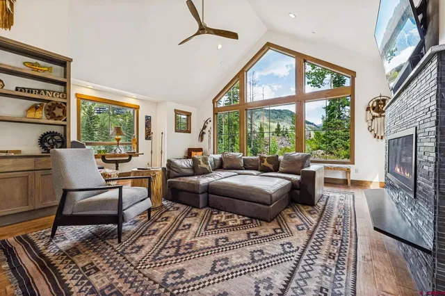 a living room with furniture a fireplace and a floor to ceiling window