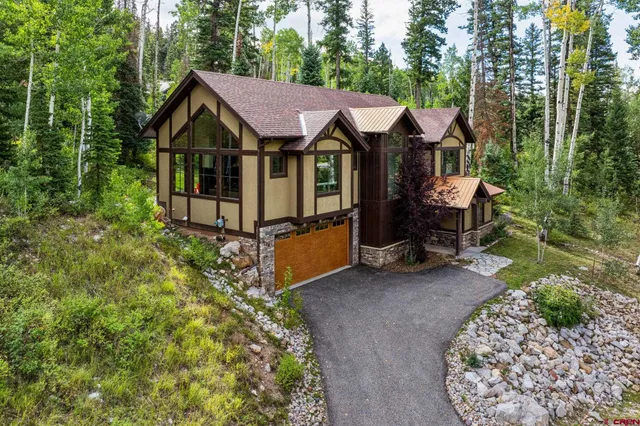 a view of a house with a yard and large trees