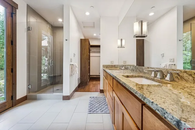 a bathroom with a granite countertop sink mirror and shower