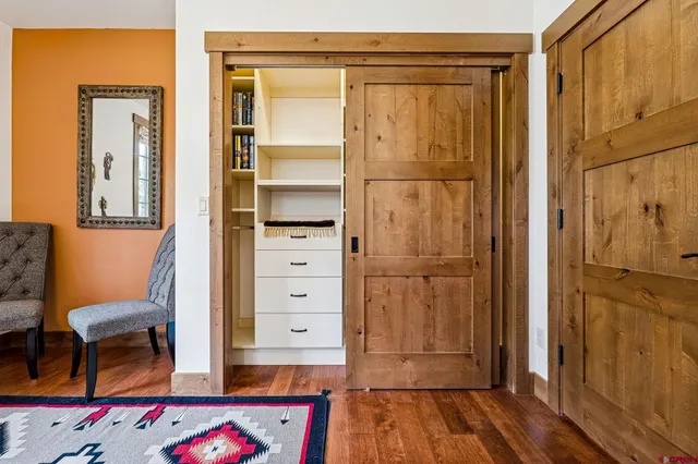a view of walk in closet with furniture and wooden floor