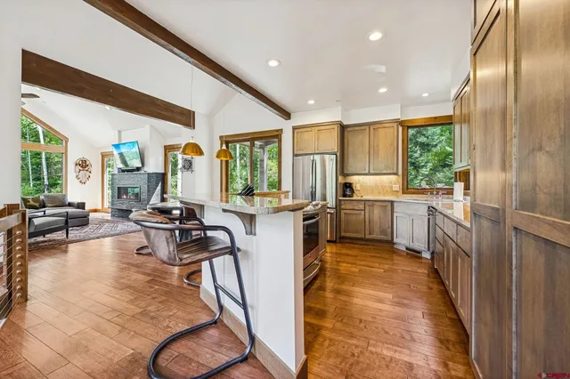 a kitchen with sink refrigerator and large window