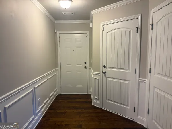 a view of a hallway with wooden floor and staircase