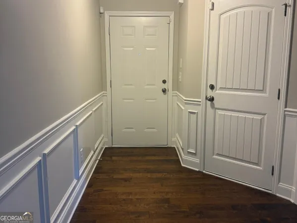 a view of a hallway with wooden floor and staircase