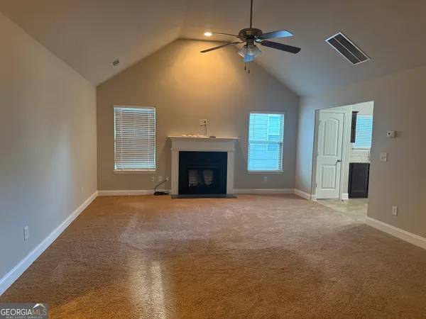 a view of an empty room with a fireplace and a window