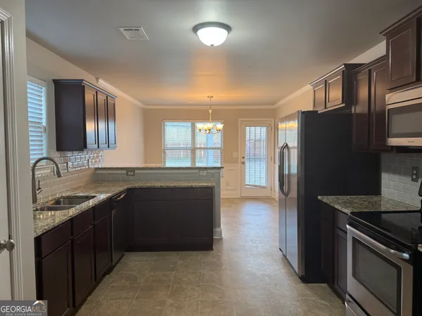 a kitchen with a sink stove and refrigerator