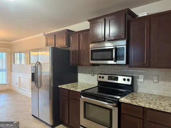 a kitchen with stainless steel appliances granite countertop a refrigerator stove and microwave