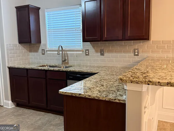 a kitchen with granite countertop a sink stainless steel appliances and cabinets