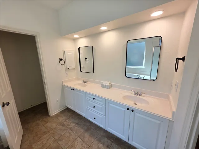 a bathroom with a double vanity sink and a mirror