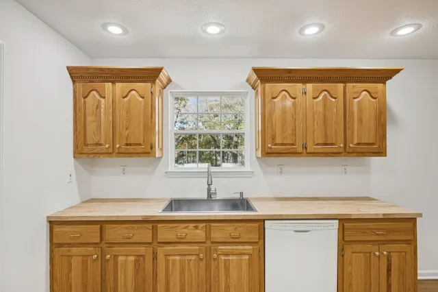 a kitchen with stainless steel appliances granite countertop a sink and dishwasher with wooden cabinets