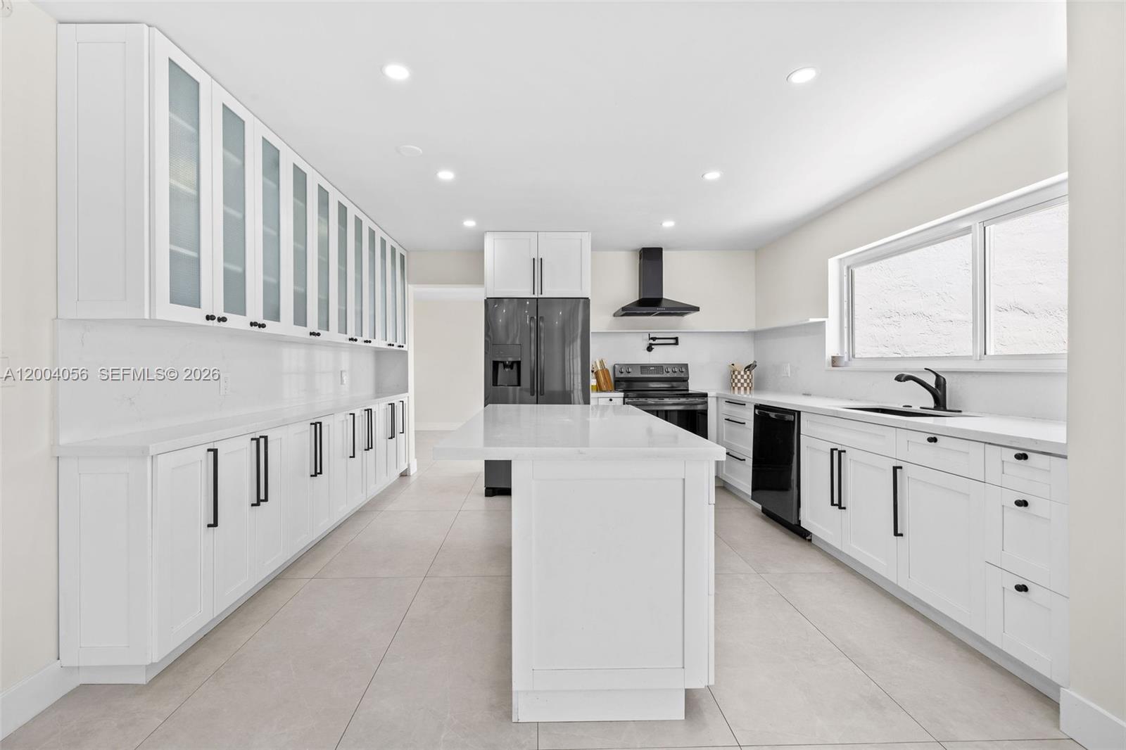 9547 Southwest 146th Place Miami, FL 33186 - Photo 11 of 40 a kitchen with cabinets and window
