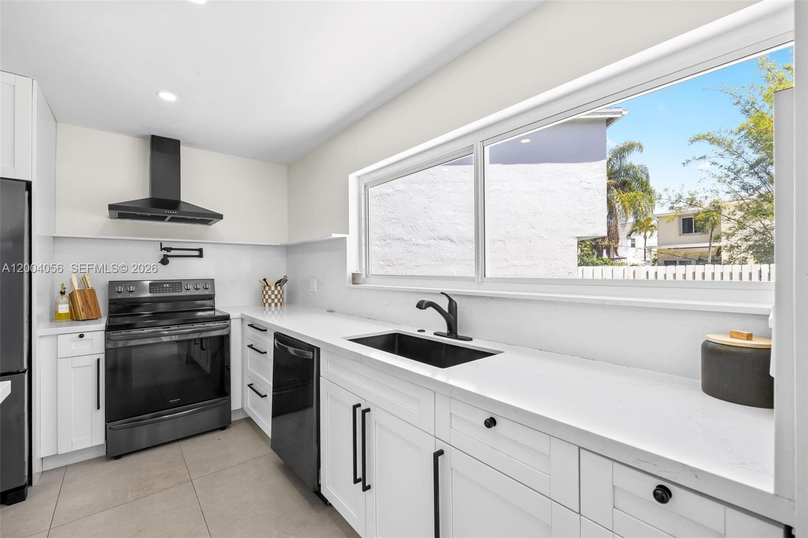 9547 Southwest 146th Place Miami, FL 33186 - Photo 12 of 40 a kitchen with stainless steel appliances a sink stove and a refrigerator