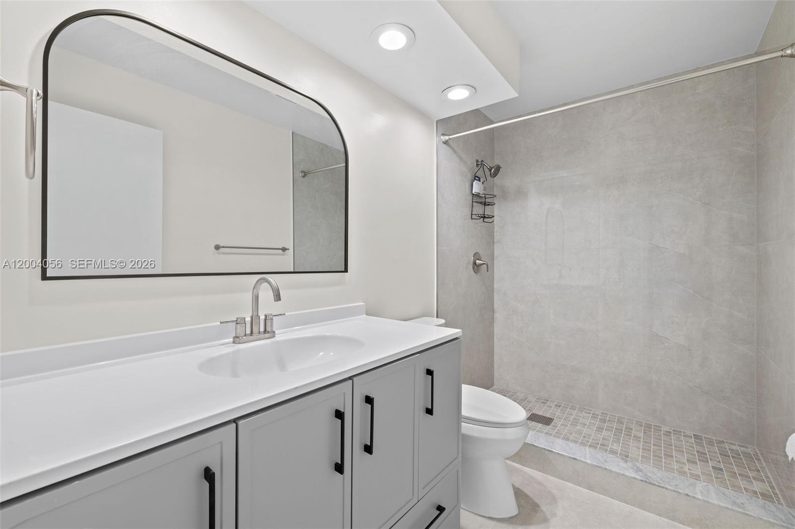 9547 Southwest 146th Place Miami, FL 33186 - Photo 17 of 40 a bathroom with a double vanity sink toilet and shower