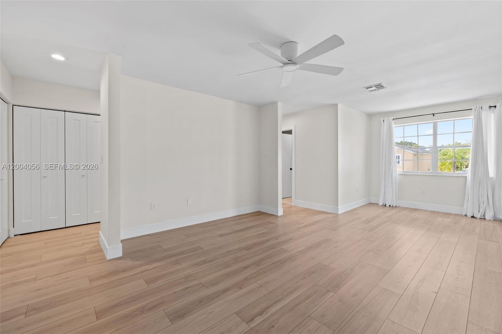 9547 Southwest 146th Place Miami, FL 33186 - Photo 21 of 40 an empty room with wooden floor closet and windows