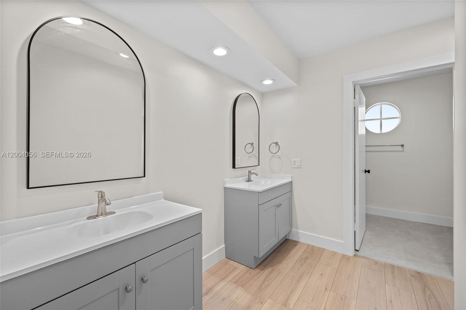9547 Southwest 146th Place Miami, FL 33186 - Photo 23 of 40 a bathroom with a double vanity sink and mirror
