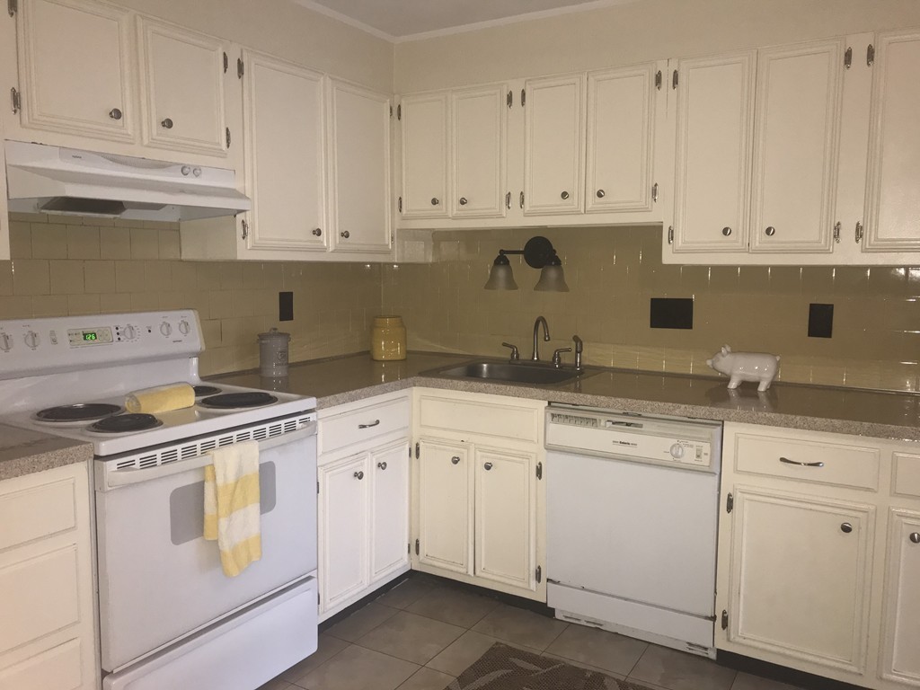a kitchen with white cabinets and white appliances