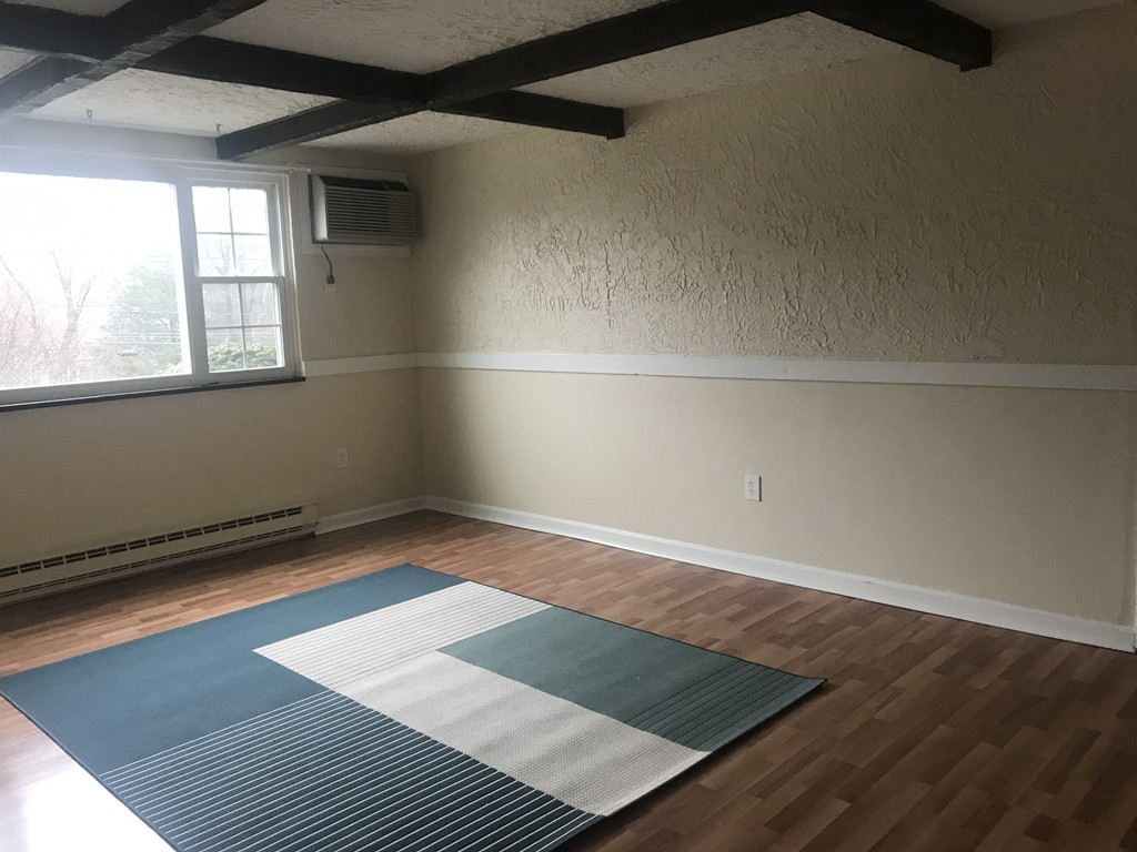 120 Parker Street, Unit 25 Acton, MA 01720 - Photo 5 of 11 an empty room with wooden floor and windows