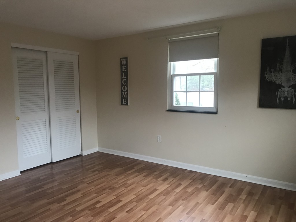 120 Parker Street, Unit 25 Acton, MA 01720 - Photo 9 of 11 a view of an empty room with wooden floor and a window