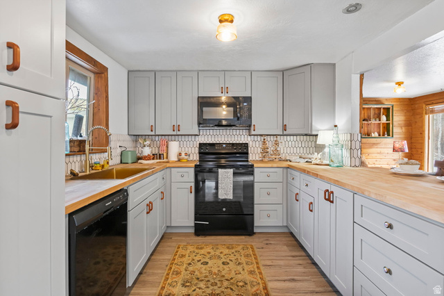 2189 Samak Park Loop, Unit 43 Kamas, UT 84036 - Photo 17 of 48 Kitchen with black appliances, plenty of natural light, butcher block countertops, light wood-style floors, and wooden walls