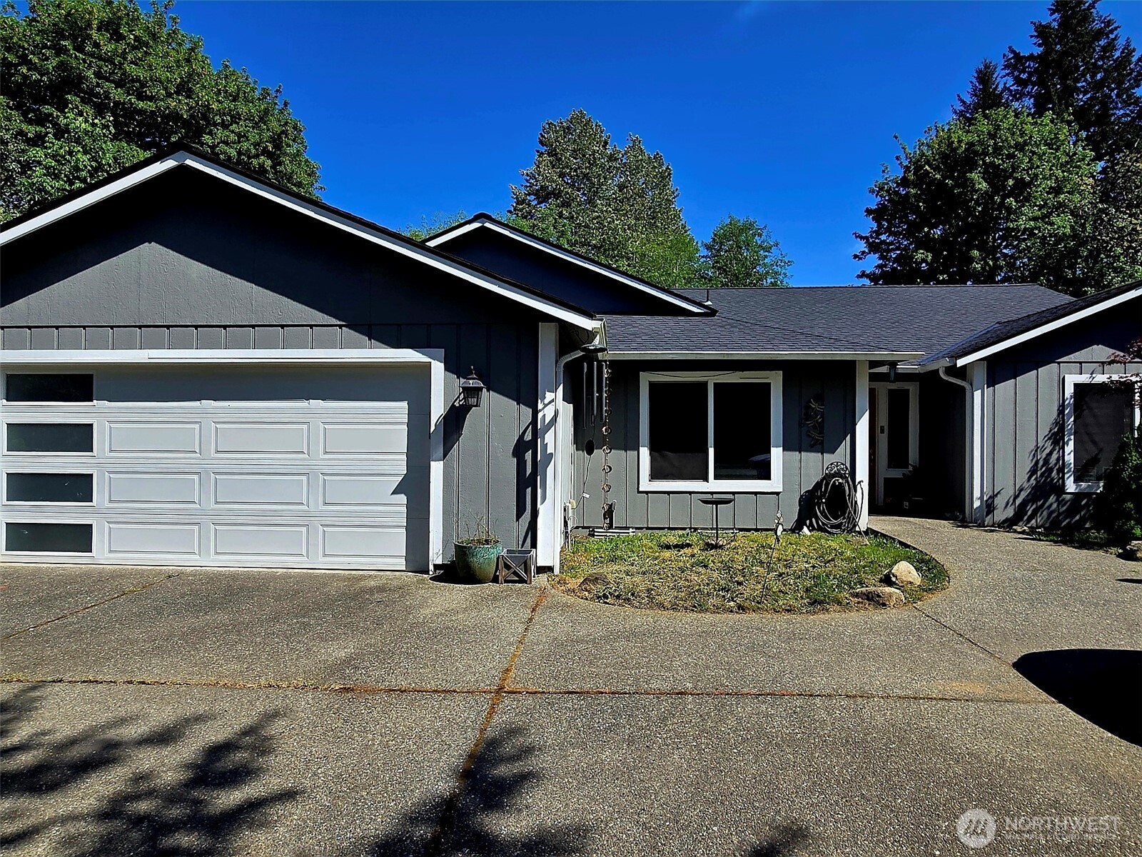 6611 Crescent Beach Road Northwest Vaughn, WA 98394 - Photo 1 of 17 a front view of a house with a yard and garage