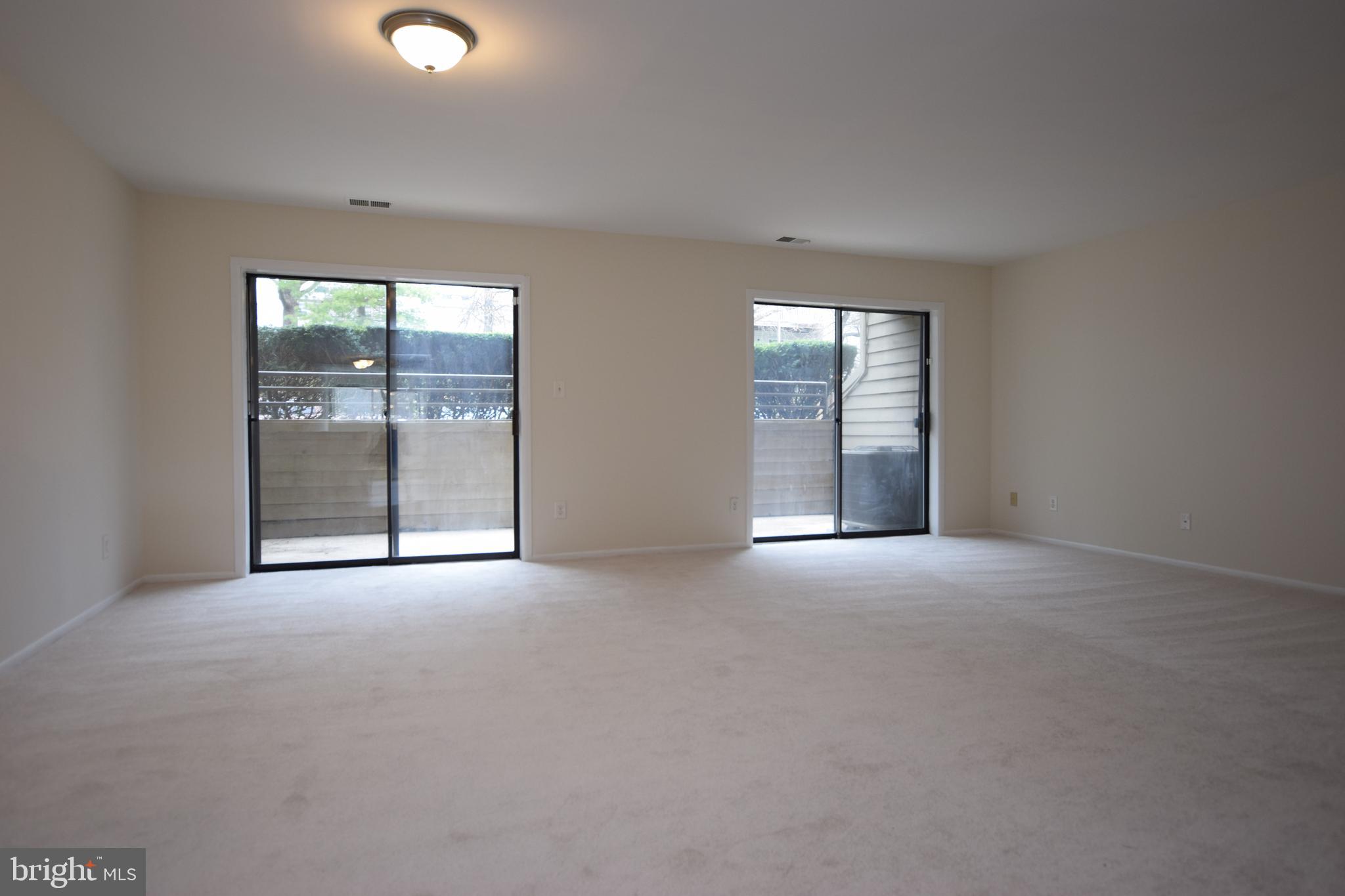 6907 Jones View Drive, Unit 1B Baltimore, MD 21209 - Photo 5 of 25 Living Room has 2 Sliders to Patio