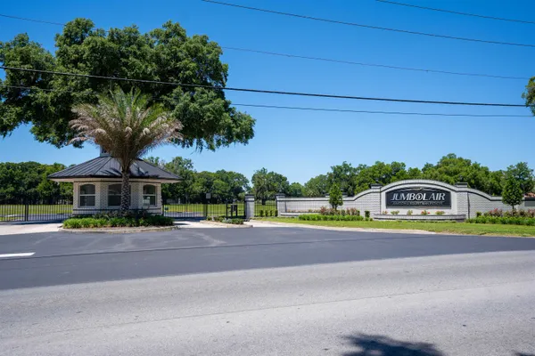 a front view of a house with a garden and trees