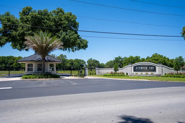a front view of a house with a garden and trees