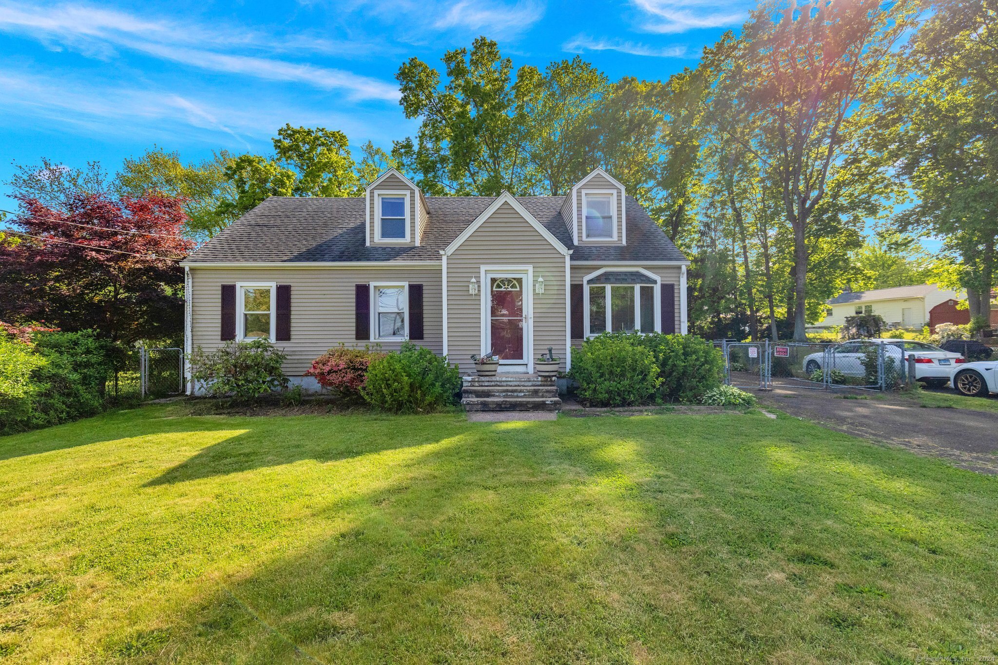 a front view of a house with a garden and trees
