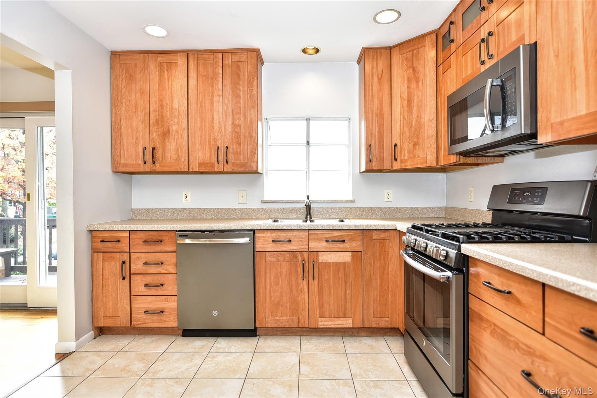 33 Hillcrest Road Suffern, NY 10901 - Photo 14 of 39 Kitchen featuring stainless steel appliances, light stone counters, brown cabinets, light tile patterned flooring, and recessed lighting