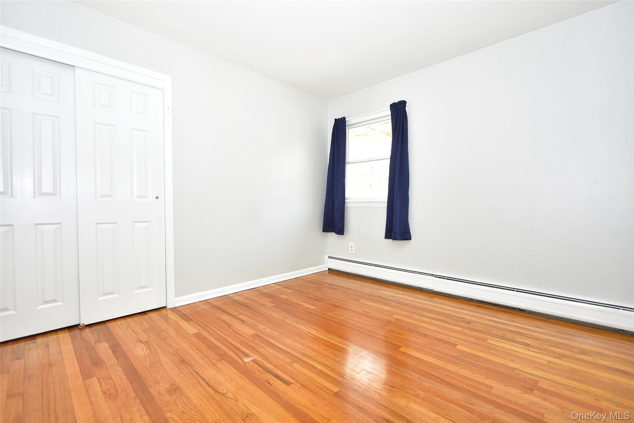 33 Hillcrest Road Suffern, NY 10901 - Photo 20 of 39 Unfurnished bedroom featuring a baseboard heating unit, light wood-type flooring, and a closet