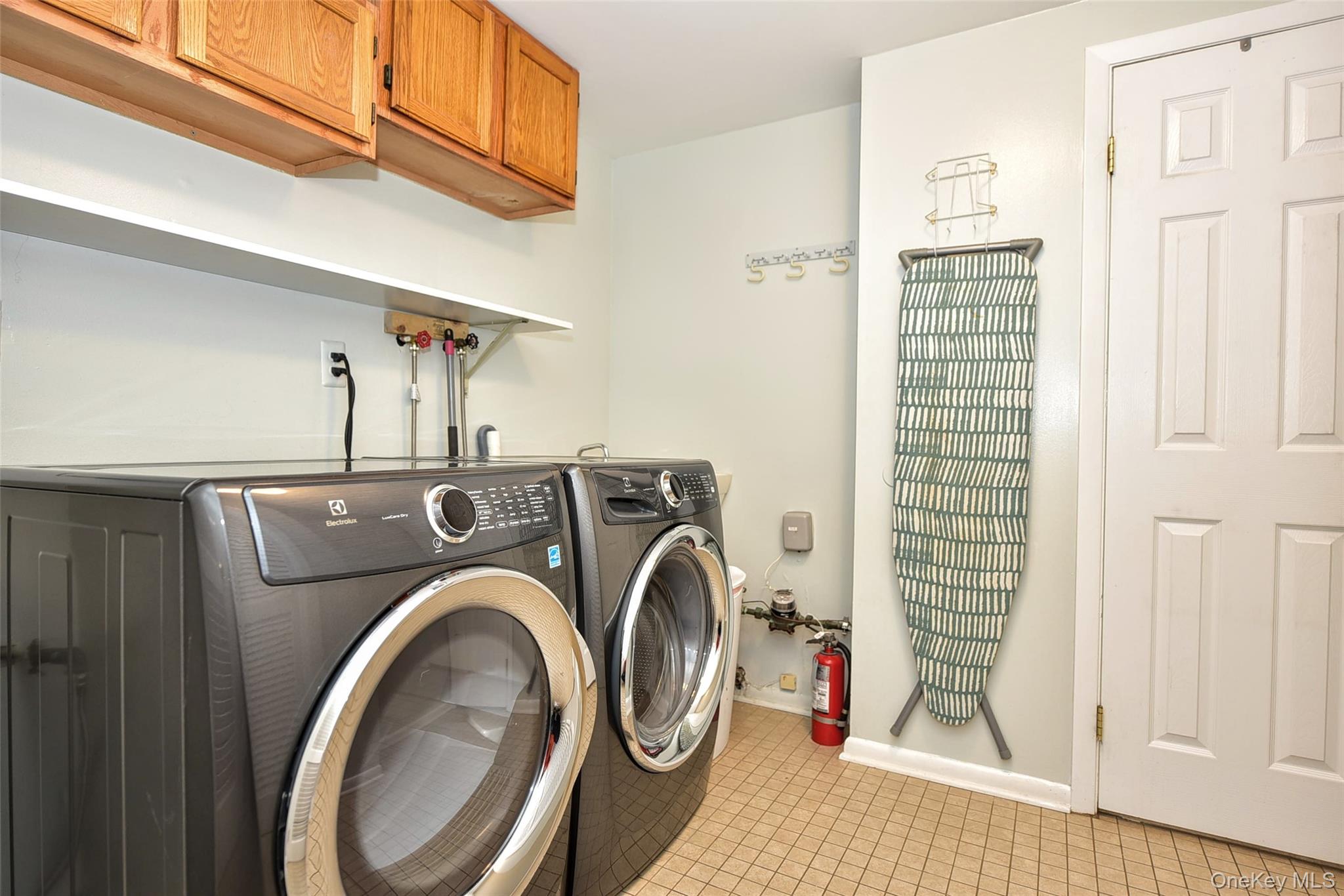 33 Hillcrest Road Suffern, NY 10901 - Photo 28 of 39 Laundry area featuring cabinet space, light tile patterned floors, and washing machine and clothes dryer