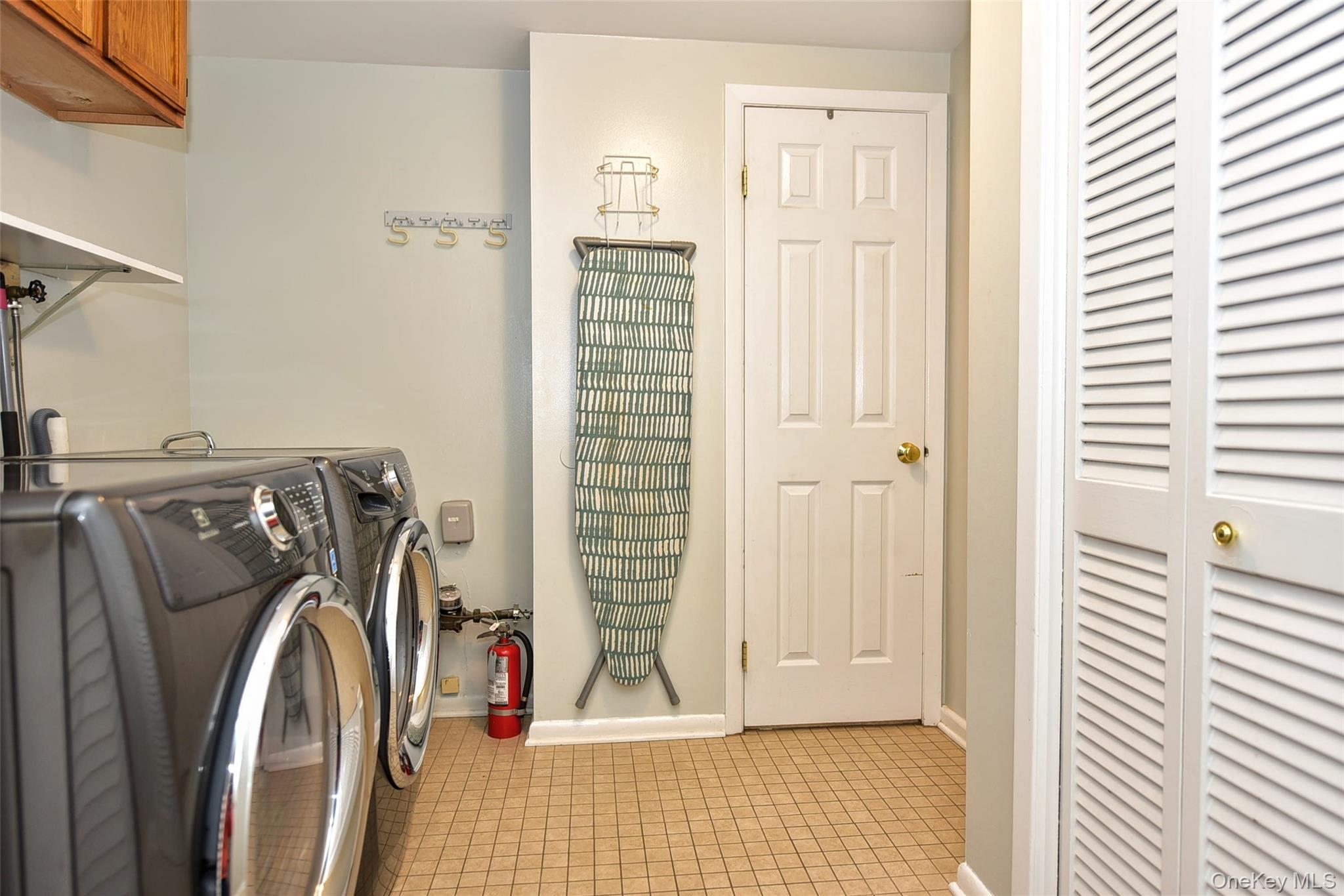 33 Hillcrest Road Suffern, NY 10901 - Photo 29 of 39 Laundry area with light tile patterned floors, washer and dryer, and cabinet space