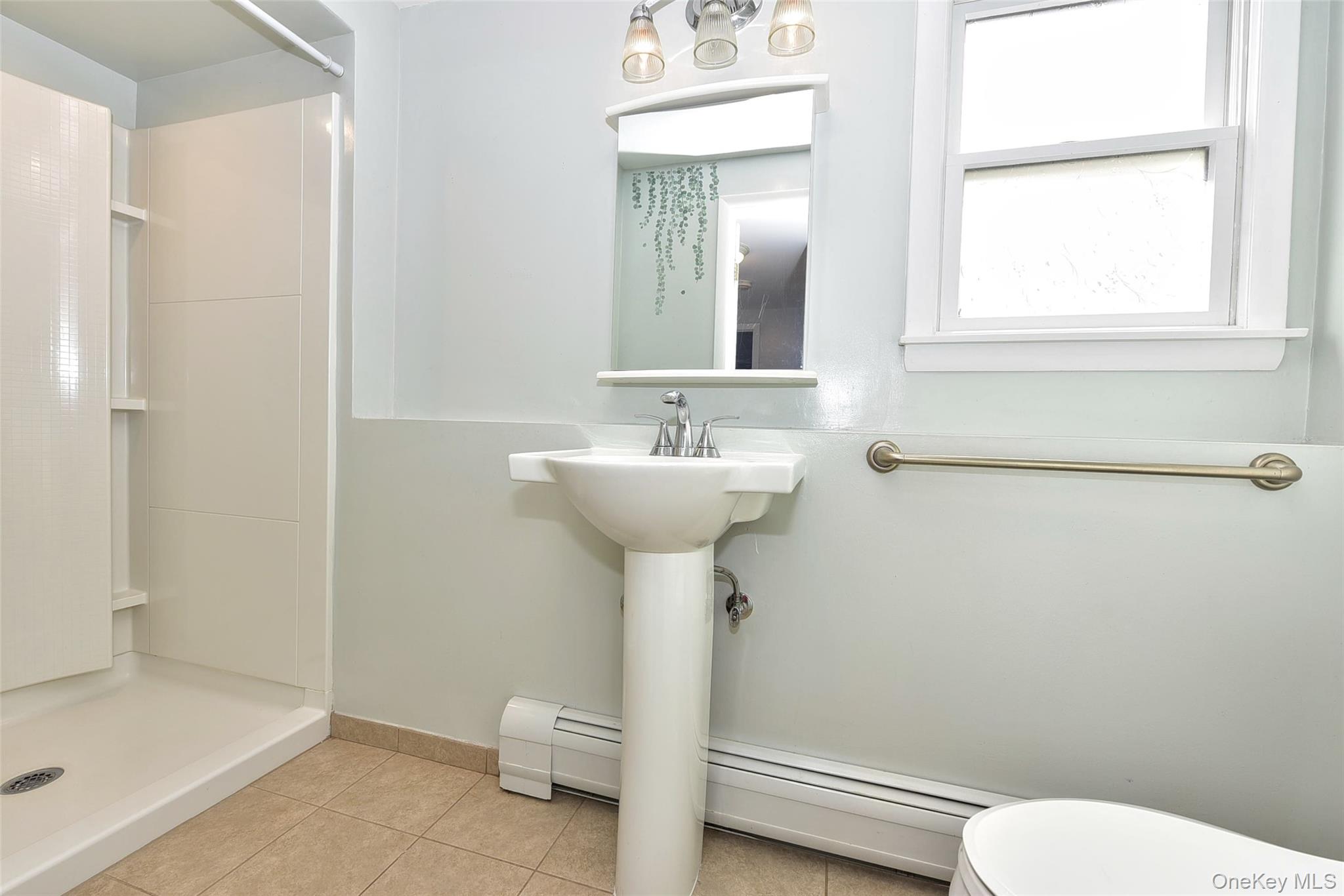 33 Hillcrest Road Suffern, NY 10901 - Photo 30 of 39 Bathroom featuring a shower stall, light tile patterned floors, baseboard heating, and a baseboard heating unit