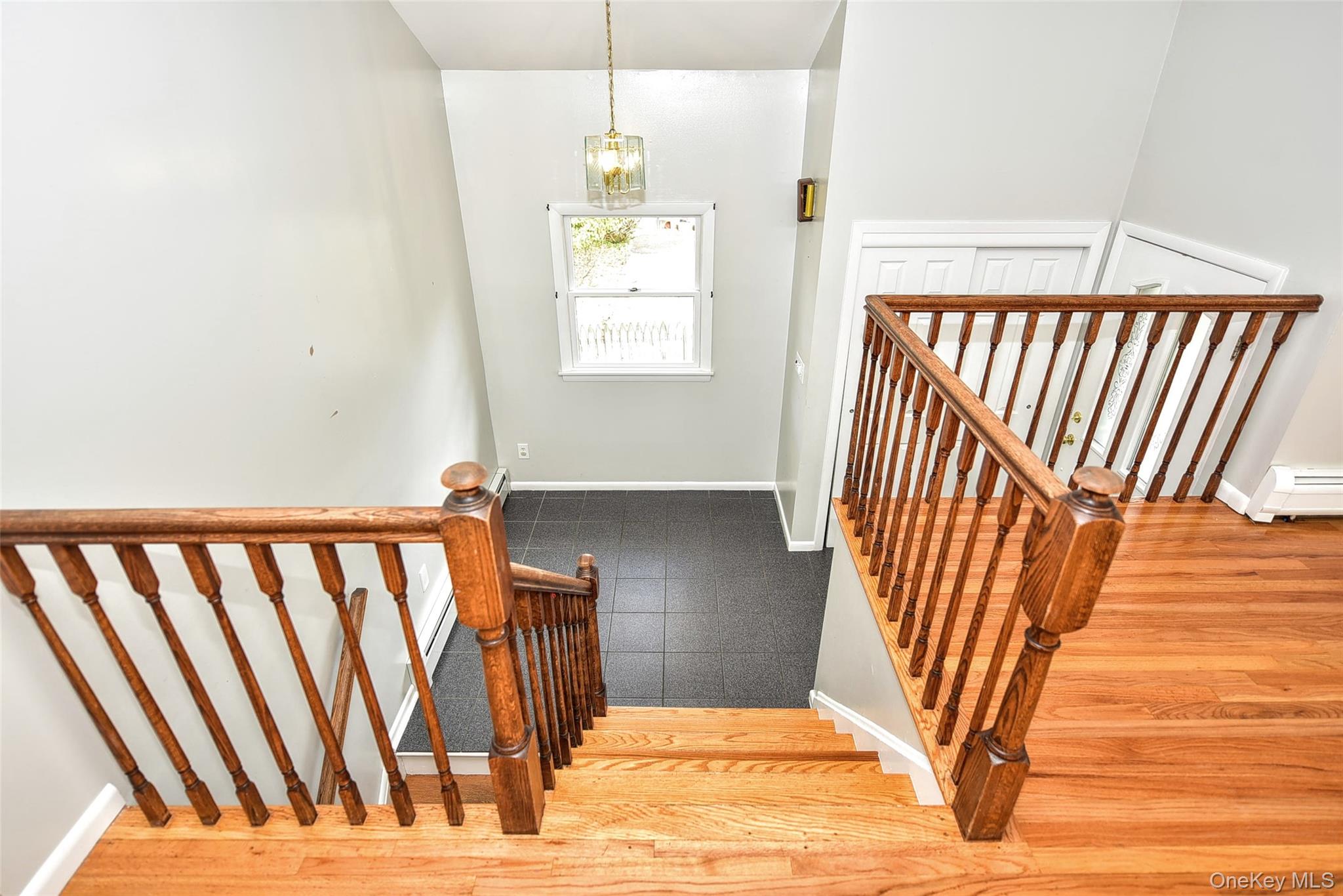 33 Hillcrest Road Suffern, NY 10901 - Photo 5 of 39 Stairway with wood finished floors, a chandelier, and a baseboard heating unit