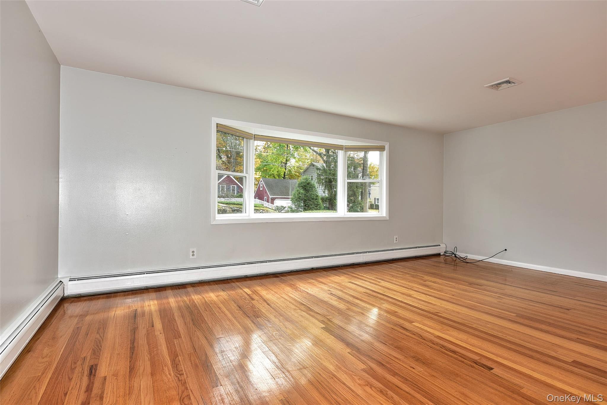 33 Hillcrest Road Suffern, NY 10901 - Photo 6 of 39 Empty room with light wood-type flooring, a baseboard radiator, and a baseboard heating unit