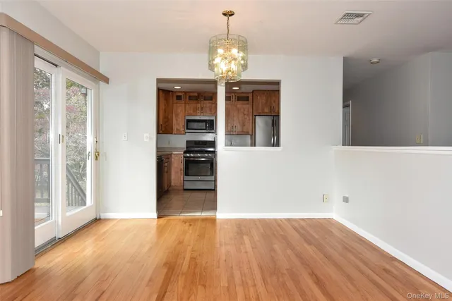 a dining room with furniture a chandelier and wooden floor