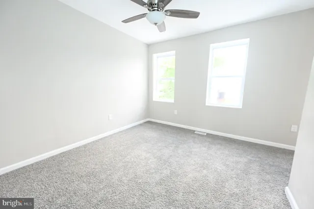 an empty room with a window and a fan
