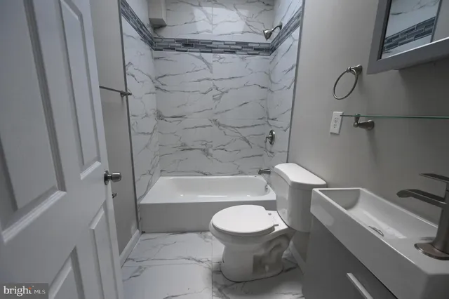a white toilet sitting next to a bath tub and a shower